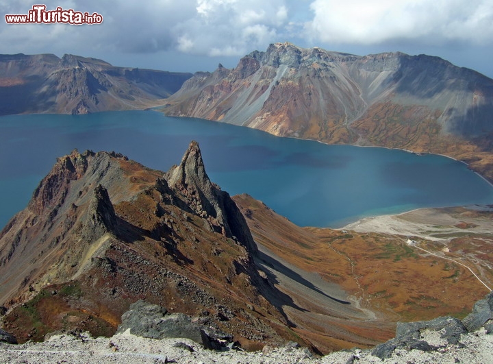 Lago vulcanico sul monte Paktusan (Baekdu), Corea del Nord - E' anche chiamato come Lago del Paradiso, e si trova a nord, lungo il confine con la Cina  che taglia a metà lo specchio d'acqua. Si tratte di una grande caldera vulcanica, ancora in attività, e quindi potenzialmente a rischio. In effetti presenta un tasso di sollevamento pari a 3 mm l'anno, e potrebbe essere prossima ad una nuova fase eruttiva, particolarmente pericolosa, visto la presenza abbondante di acqua! L'ultima eruzione avvenne nel 1903, e in virtù della storia che ha visto ripetersi di eventi con intervalli di circa 1 secolo, questo luogo potebbe essere vicinissimo ad una ripresa dell'attività vulcanica. Ricordiamo che dal lal lago si generano anche delle spettacolari cascate.

© Maxim Tupikov / Shutterstock.com