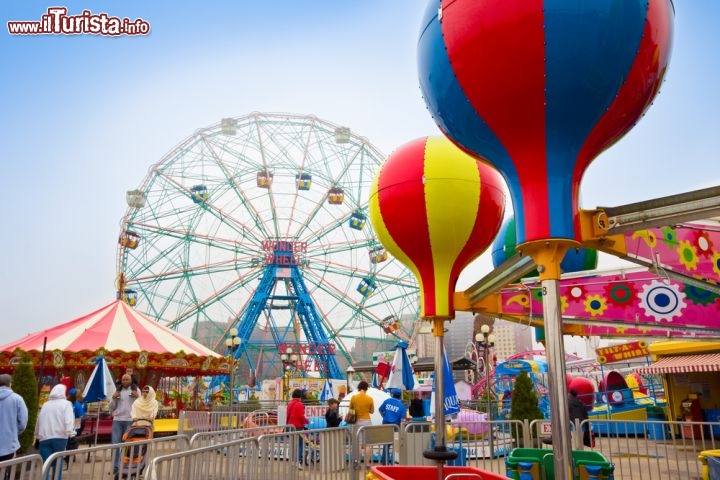 Immagine I colori del Luna Park di Coney island, con la grande ruota panoramica di Wonder Wheel sullo sfondo, una delle attrazioni più celebri di New York - © littleny / Shutterstock.com