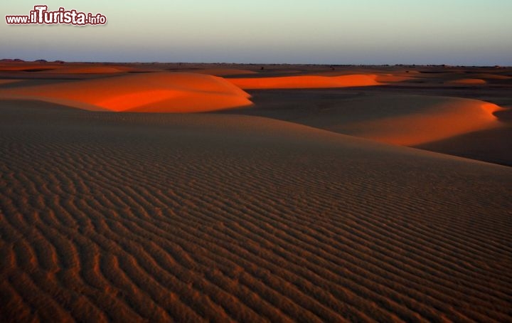 Fotografia al tramonto nel deserto occidentale del Sudan. La luce del radente del sole colpisce la cresta di alcune dune di sabbia - Per ulteriori informazioni: I viaggi di Maurizo Levi ed in particolare il Tour del Regno dei Faraoni Neri