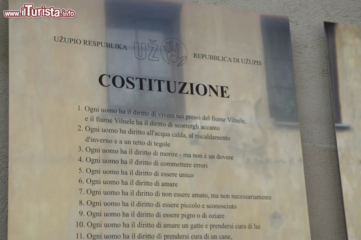 Immagine Nella foto i primi articoli della Costituzione della Repubblica di Uzupis in Italiano.

Qui tutti e 41 gli articoli della costituzione:
1. Ogni uomo ha il diritto di vivere vicino al fiume Vilnia e il fiume ha diritto di scorrergli a fianco.
2. Ogni uomo ha il diritto all’acqua calda, al riscaldamento d’inverno e ad un tetto di tegole
3. Ogni uomo ha il diritto di morire ma non è un dovere
4. Ogni uomo ha il diritto di commettere errori
5. Ogni uomo ha il diritto di essere unico
6. Ogni uomo ha il diritto di amare
7. Ogni uomo ha il diritto di non essere amati, ma non necessariamente
8. Ogni uomo ha il diritto di essere piccolo e sconosciuti
9. Ogni uomo ha il diritto di essere pigro o di oziare
10. Ogni uomo ha diritto di amare un gatto e prendersi cura di lui
11. Ogni uomo ha il diritto di badare al cane fino a quando uno dei due muore
12. Il cane ha diritto di essere un cane
13. Il gatto non è obbligato ad amare il suo padrone, ma deve essere di aiuto nei momenti di necessità
14. A volte si ha il diritto di essere inconsapevoli dei propri doveri
15. Ogni uomo ha il diritto di avere dei dubbi, ma non è obbligatorio
16. Ogni uomo ha il diritto di essere felici
17. Ogni uomo ha il diritto di essere infelici
18. Ogni uomo ha il diritto di stare in silenzio
19. Ogni uomo ha il diritto di avere fede
20. Nessuno ha il diritto di usare violenza
21. Ogni uomo ha il diritto di apprezzare la propria scarsa importanza
22. Nessuno ha il diritto di avere un progetto per l’eternità
23. Ogni uomo ha il diritto di comprendere
24. Ogni uomo ha il diritto di non capire
25. Ogni uomo ha il diritto di appartenere a qualunque nazionalità
26. Ogni uomo ha il diritto di celebrare o non celebrare il proprio compleanno
27. Tutti devono ricordare il proprio nome
28. Ogni uomo ha il diritto di dividere ciò che posseggono
29. Nessuno può dividere ciò che non possiede
30. Ogni uomo ha il diritto di avere fratelli, sorelle e parenti
31. Tutti possono essere indipendenti
32. Tutti sono responsabili della propria libertà
33. Tutti devono poter piangere
34. Ogni uomo ha il diritto di essere fraintesi
35. Nessuno ha il diritto di dichiarare colpevole il prossimo
36. Ogni uomo ha il diritto all’individualità
37. Ogni uomo ha il diritto di non avere diritti
38. Ogni uomo ha il diritto di non avere paura
39. Non deludere
40. Non combattere
41. Non cedere