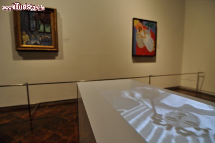 Un filmato di Matisse proiettato su di un piano,  e sullo sfondo le sue opere esposte a Ferrara al Palazzo dei Diamanti