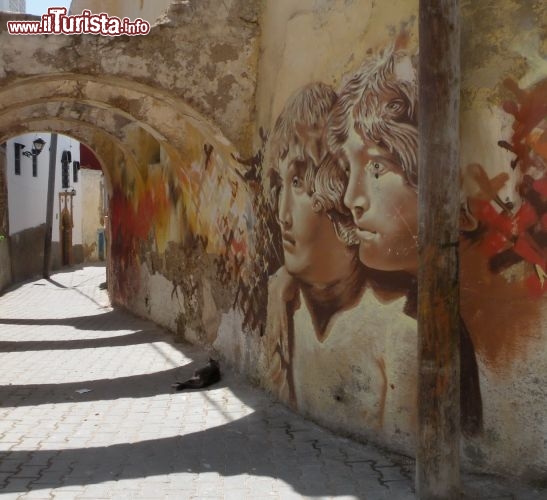 La colorata medina di Azemmour, la città degli artisti del Marocco - A distanza di pochi chilometri da El Jadida incontriamo un sito antico ed ancora lontano delle tradizionali rotte turistiche: la città di Azemmour. Il nome berbero di questo luogo significa un albero di ulivo che non produce frutti.
Chiamata anche “La città dei Artisti”, Azemmour accoglie le opere di visionari artisti locali che affidano a colori sgargianti ed alla pietra delle pareti delle case il loro messaggio universale. Gli edifici diroccati ed i piccoli forni che si affacciano sulle strette e ripide vie di questa antica città sono intervallati da sgargianti dipinti che pare fuoriescano dai muri ad animare la Medina.