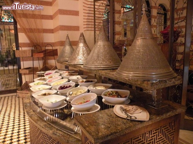 Immagine Ristorante Market Place al Mazagan Resort - Dalla maestosa lobbies si accede a tre ristoranti: il Ristorante Sel De Mer, arredato con gusto e sobrietà, dove viene servito il pescato del giorno, le famose ostriche di Oualidia, e il tradizionale pollo Piri Piri di derivazione Portogese; il ristorante Market Place dove il protagonista è un vasto buffet dove le pietanze internazionali si accostano con raffinata armonia a piatti tipici mediorientali, magrebini, indiani e asiatici. Al centro del ristorante Market Place troviamo un grande forno circondato da due griglie per cuocere pesci freschissimi e carni saporite, lateralmente sono collocati ricchi buffet di verdure, creme e legumi ed un vasto assortimento di frutta e dolci tipici marocchini