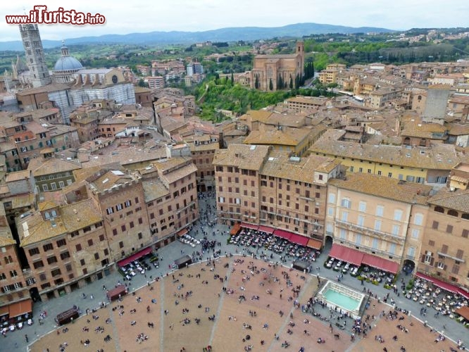 Immagine Piazza del Campo vista dalla sommità della Torre del Mangia ad 88 metri d'altezza. Sullo sfondo a sinistra, la Cattedrale e a destra, circodato dal verde, il Santuario casa Santa Caterina