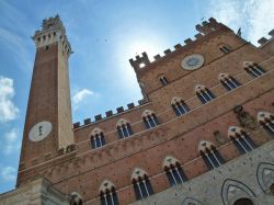 Facciata del Palazzo Pubblico di Siena e l'imponente Torre del Mangia, sotto la cui ombra sta Piazza del Campo