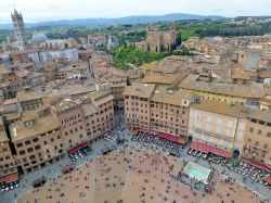 Piazza del Campo vista dalla sommità della Torre del Mangia ad 88 metri d'altezza. Sullo sfondo a sinistra, la Cattedrale e a destra, circodato dal verde, il Santuario casa Santa ...