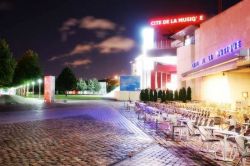 Foto notturna della Citè de la Musique a Parigi, all'interno del bel Parc de la Villette, a nord-est del centro della capitale della Francia. Sulla destra il Café del la Musique, ...