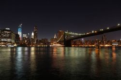 Fotografia di notte del Ponte di Brooklyn illuminato, sulla sx la Freedom Tower illuminata con i colori della bandiera americana - © Tupungato / Shutterstock.com