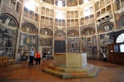 Visitare il Battistero di Parma: al centro la grande fonte battesimale in marmo, e le pareti riccamente decorate