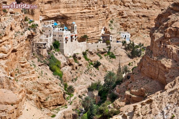 Monastero di San Giorgio, Israele - Uno scenario tutto diverso incornicia il Monastero di San Giorgio di Koziba, situato nel bel mezzo del deserto israeliano, a una ventina di chilometri da Gerusalemme: canyon modellati dal vento, strapiombi di rocce stratificate e spettacolari speroni sospesi sul vuoto caratterizzano il paesaggio, che sa mettere in soggezione i suoi ospiti e farli sentire piccoli piccoli. Il monastero greco ortodosso sembra aggrappato alla montagna con tutte le sue forze, come per dare un’occhiata al sottostante canyon del Wadi Qelt. Eppure, in quella posizione, ha resistito oltre 1500 anni, da quando un piccolo gruppo di monaci si spinse nel deserto per provare ciò che avevano vissuto Giovanni Battista e lo stesso Gesù Cristo: per fondare il monastero scelsero un luogo significativo, dove secondo la tradizione Elia era stato nutrito dai corvi, come racconta il primo Libro dei Re. Ancora oggi alcuni monaci greco-ortodossi vivono nel Monastero di San Giorgio, e sono pronti ad accogliere i pellegrini nel loro luogo sacro, con la bella chiesa della Vergine Maria, il reliquiario in cui sono conservati i resti dei monaci uccisi dai persiani nel lontano 614, la grotta in cui visse il profeta Elia per 3 anni e i rigogliosi giardini alimentati da un ruscello, incredibilmente verdi in mezzo al deserto. Visitando il complesso vi si spalancheranno davanti panorami mozzafiato, proprio come accade da secoli ai monaci che un tempo, a quanto pare, si ritiravano a meditare e pregare nelle fenditure della montagna. I classici tour nella Terra Santa privilegiano Gerusalemme e Gerico, ma il monastero di San Giorgo meriterebbe davvero una tappa extra.
Come arrivare? Lungo la strada che collega Gerusalemme a Gerico, procedendo in direzione Mar Morto, basta seguire le indicazioni verso Mitzpeh Yeriho e prendere la strada che porta al canyon di Nahal Prat. Una volta parcheggiato si prosegue a piedi per qualche minuto, lungo un saliscendi non particolarmente arduo - © makarenko7 / Shutterstock.com