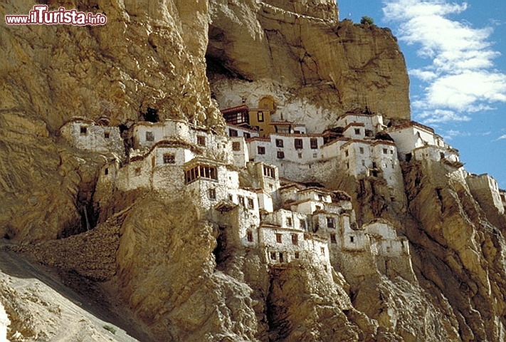 Monastero di Phugtal (o Puktal) in India - Ancora India e ancora Himalaya, questa volta per visitare il monastero buddista di Phuktal Gonpa, nella remota Valle Lungnak, regione di Ladakh. Il complesso attuale risale all’inizio del XIV secolo, quando venne fondato da Jangsem Sherap Zangpo, ma già intorno a 2.500 anni fa si ritiene che importanti personaggi della cultura indiana, saggi e maestri, visitassero questi luoghi e si fermassero a pregare nelle caverne naturali. Ancora oggi si può visitare la grotta sulle cui pareti sono ritratti i 16 “Arhats”, i leggendari seguaci del Buddha, e dove pare abbia vissuto per un periodo il maestro Lama Marpa. Tutt’intorno alla grotta si è poi sviluppato il complesso monastico, rappresentato da un tempio principale, stanze di preghiera, una biblioteca, numerosi appartamenti, sale dove avvengono gli insegnamenti della tradizione buddista tibetana, e ovviamente le cucine… perché anche i più saggi devono pur mangiare. Nonostante l’aspetto eremitico, incastonato com’è tra le rocce, il monastero è aperto al resto del mondo e ha un efficiente sito internet contenente informazioni di vario genere. Periodicamente vi si svolgono cerimonie e “festival” a cui possono prendere parte anche ospiti esterni, per tramandare le antiche usanze e permettere ai monaci e ai visitatori di “accumulare karma positivo” per le prossime vite attraverso la preghiera o le donazioni. Non importa però che crediate alla reincarnazione: un soggiorno al Monastero di Phuktal è prima di tutto un’occasione per conoscere dei veri monaci tibetani (attualmente ce ne sono una settantina), condividere con loro un pezzo di vita, e contemplare indisturbati scenari decisamente fuori dall’ordinario.
Come arrivare? Il Phuktal Gompa è raggiungibile soltanto a piedi, quindi preparatevi a un percorso avventuroso! Atterrati a Delhi si può prendere un volo interno per Leh, capitale del Ladakh, e proseguire all’esplorazione dello Zanskar prenotando le solite jeep. C’è una mulattiera, sempre percorribile in jeep, che risale il fiume Tsarap fino al villaggio di Ichar, oltre la città di Mune: da qui comincia il sentiero per Phuktal, da percorrere a piedi (occorrono un paio di giorni) oppure a cavallo. Panorami mozzafiato e qualche vertigine sono assicurati - © Shakti, CC BY-SA 3.0 / wikipedia.org