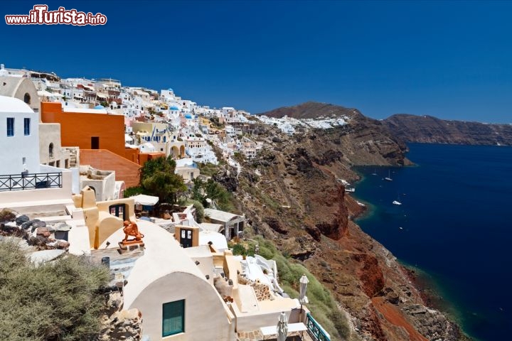 Fira sull’isola di Santorini, in Grecia - Clima mediterraneo, tramonti da favola, acqua limpidissima e casette bianche con le finestre blu affacciate sul mare: Santorini è tutto questo, e molto di più. La celebre isola greca – presa d’assalto ogni anno anche per le discoteche e la inarrestabile vita notturna – in realtà è un paradiso naturale sotto forma di vulcano, la cui capitale, Fira, si è sviluppata sulla parte più alta della caldera, a quota 260 metri. Abbarbicate alle rocce come conchiglie sugli scogli, le case di Fira godono di un panorama da sogno, tanto che molti turisti scelgono di salire in paese a piedi dal porto, percorrendo 525 gradini, oppure in groppa ai muli, per assaporare ogni più piccola briciola di panorama e guadagnarsi la vista di questa incantevole cittadina.
Fira sorge a 5 km dall'aeroporto internazionale di Santorini e a 8 km dal porto Athinios  - © Ochkin Alexey / Shutterstock.com 