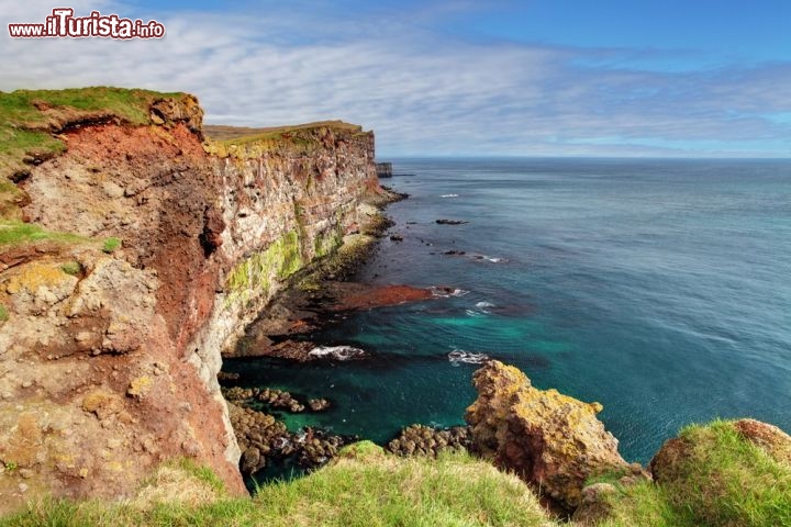 Látrabjarg, all’estremità occidentale dell’Islanda - Tra le scogliere più affascinanti del mondo c’è senza dubbio quella di Látrabjarg, che oltre a rappresentare il lembo più occidentale dell’Islanda è anche quello più occidentale d’Europa: a sud di questo sperone roccioso si sviluppa una scogliera grandiosa, lunga 14 km e alta più di 400 metri, con pareti verticali a picco sull’Oceano Atlantico. Ogni anno è visitata da innumerevoli specie di uccelli migratori, che la scelgono per la riproduzione, mentre la folla di turisti è un po’ meno guarnita.
Il punto è che raggiungere Látrabjarg non è così semplice, trovandosi a quasi 450 km da Reykjavik: una distanza notevole, soprattutto se si considera che si tratta perlopiù di strada sterrata e agibile solo d’estate, che richiede un giorno intero di viaggio senza fermarsi. Una volta arrivati al faro di Látrabjarg la falesia sale in direzione est, dove si trova il punto più bello e panoramico… per conquistarlo “basta” camminare per 8 km in salita, ma chi ci è riuscito assicura che ne vale la pena  - © TTstudio / Shutterstock.com 