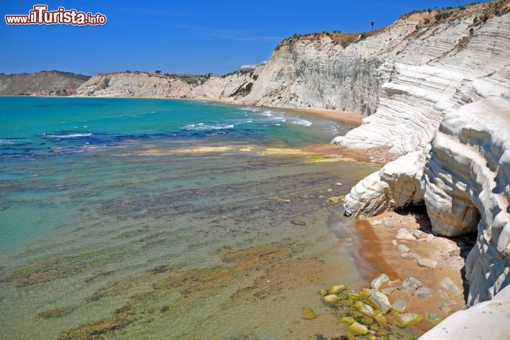 Scala dei Turchi in Sicilia - Nel sud dell'isola di Tinacria, non distante da Agrigento e Porto Empedocle, la cosiddetta costa di Realmonte presenta una tratto davvero spettacolare: rocce bianche stratificate si tuffano a capofitto nel Mediterraneo, creando uno scenario di rara suggestione. Secondo la tradizione i pirati saraceni "li Turchi" approdavano su queste coste per compiere le loro scorribande all'interno della Sicilia. La particolare morfologia di queste rocce, chiamate marne dai geologi, crea una serie di terrazzamenti che potevano essere usate dai pirati come delle particolari scale d'accesso. Il colore chiaro di queste argille a cemento calcareo rende le acque ancora più turchesi e invitanti al bagno. Ricordiamo infine come questa costa sia compresa tra i luoghi del Commissario Montalbano, la fortunata serie televisiva ispirata dai romanzi di Andrea Camilleri  - © myzblka / Shutterstock.com