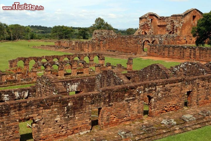 La Santísima Trinidad de Paraná, Paraguay
I locali le chiamano semplicemente “rovine di Trinidad”: sono i resti di una missione gesuita, ovvero di una piccola colonia fondata da missionari gesuiti in Paraguay nel 1706. Tra il XVII e il XVIII secolo ne nacquero molte nell’America del Sud, ma questa è una delle più recenti, delle più interessanti e delle più visitate, oltre ad essere quella più facilmente accessibile. Missioni che erano come vere e proprie cittadelle in miniatura, dove niente doveva mancare per la vita dei fedeli che cercavano di integrarsi con gli indigeni: la piazza centrale, la chiesa, i negozi e la scuola ne facevano una piccola realtà autosufficiente. A detta dei viaggiatori di quel periodo, la chiesa di Trinidad era la più bella e la più grande di tutte le missioni; ancora oggi, varcando la soglia, si è subito rapiti dalle splendide decorazioni in pietra sopra l’altare, e non sono da meno le porte da cui si accede alle sagrestie, con i loro fregi e le loro sculture. Da vedere anche la torre a base quadrata, di cui non è chiara la funzione: poteva trattarsi di un campanile, di un osservatorio o di entrambe le cose. Le rovine, ben conservate, sono state dichiarate Patrimonio dell’Umanità dall’UNESCO nel 1993.

Si trovano a una trentina di minuti di autobus da Encarnacion, procedendo in direzione Ciudad del Este: le indicazioni per Trinidad si trovano lungo la strada. L’ingresso alla missione è a pagamento, ma chi l’ha visitata assicura che ne vale la pena.
