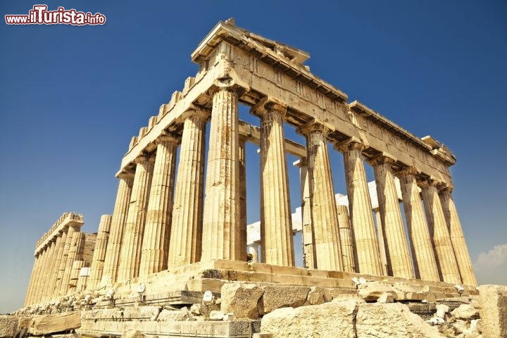 Il Partenone, Grecia
Capolavoro supremo dell’arte greca è il Partenone, che si erge in cima all’Acropoli di Atene fiero e imponente nonostante l’età. Già, perché questo tempio grandioso dedicato alla dea Atena Partenos, ovvero Atena Vergine, se ne sta nella parte più elevata dell’antica capitale sin dal V secolo a.C., dove ha sempre fatto sfoggio del più puro e raffinato stile dorico. Alla sua costruzione contribuirono gli architetti Ictino e Callicrate e il celebre scultore Fidia, ma in età moderna il Partenone si vide trasformato in chiesa cristiana e successivamente in moschea, e durante la conquista della Grecia da parte dei turchi ottomani fu addirittura utilizzato come magazzino per le armi e le munizioni. Parzialmente distrutto alla fine del Seicento durante l’assedio veneziano ad Atene, il Partenone è in fase di restauro da molto tempo e occorreranno ancora anni perché sia riportato all’antico splendore. Ciò non toglie che si tratti di un’architettura dalla bellezza magnetica ed estremamente evocativa, capace di riportarci indietro nel tempo, quando il marmo nudo che vediamo oggi era decorato a colori vivaci. In origine il tempio custodiva una statua della Dea Atena alta 12 metri, andata distrutta, di cui esiste una riproduzione al Museo Archeologico Nazionale di Atene. Nel 1987 tutta l’Acropoli è stata dichiarata Patrimonio dell’Umanità dall’UNESCO.

Giunti ad Atene è impossibile non notare il Partenone, impettito in cima a una collina: per raggiungerlo dalla città si può prendere la metropolitana e scendere alla fermata Akropoli. L’ingresso è a pagamento.  - © ivan bastien / Shutterstock.com
