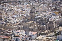 Veduta aerea del centro di Siviglia e l'imponente Cattedrale di Santa Maria la Blanca, la grande chiesa gotica dell'Andalusia (Spagna) in alto svetta la grande Giralda, la torre campanaria ...
