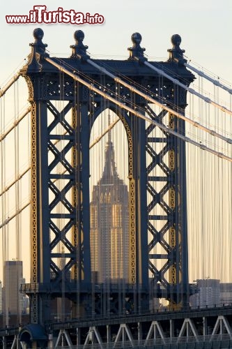 Immagine Iconica immagine di New York: L'Empire State Building si staglia attraverso le arcate del Manhattan Bridge  - © Bufflerump / Shutterstock.com