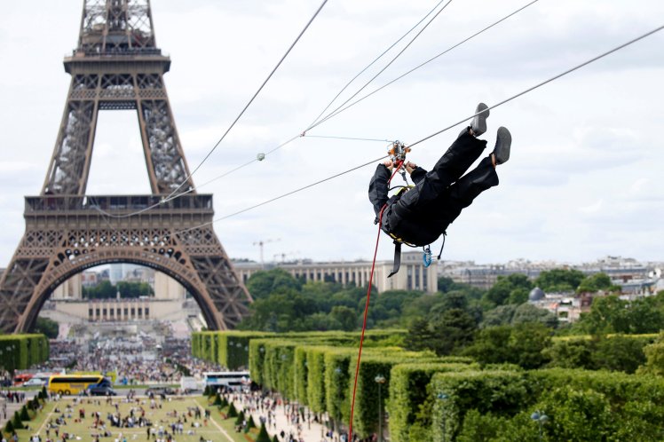 A participant rides a zip line from the second floor of the Eiffel Tower, 115 metres above the ground along an 800-metre long route, as part of a free event operating until June 11 in Paris